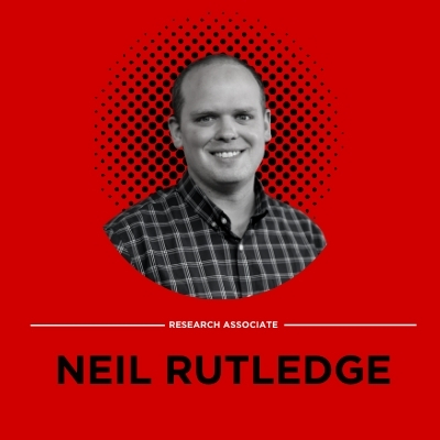 Black and white portrait of research associate Neil Rutledge on a red background